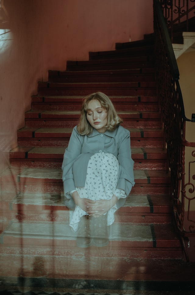depressed woman sitting on the stairs